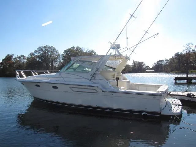 Slide: The Image of 1995 Tiara Yachts 3700 Open boat docked on a calm lake. - 47