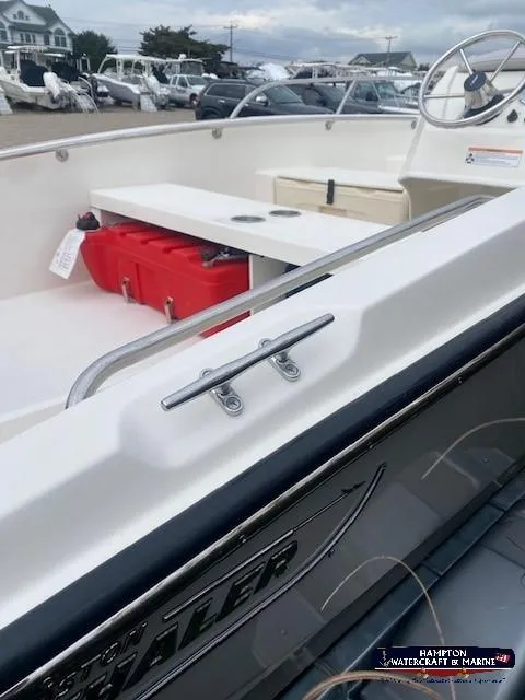 Slide: The Image of 2024 Boston Whaler 160 Super Sport interior with red storage box and steering wheel. - 9
