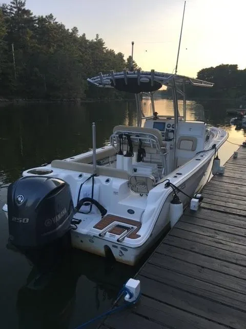Slide: The Image of 2018 Sea Fox 249 Avenger boat docked by a serene lake at sunset. - 2