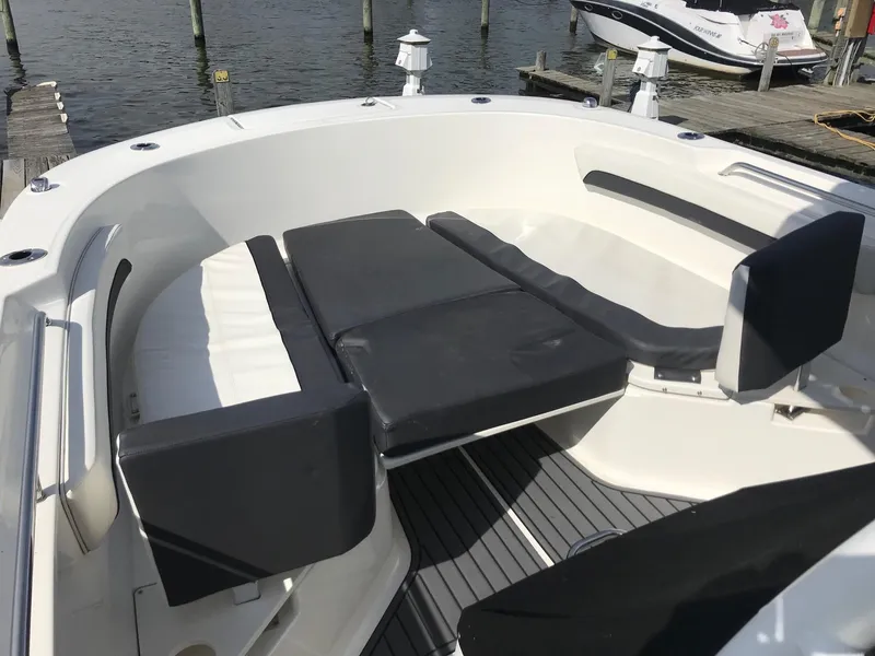 Slide: The Image of 2022 Bayliner Trophy T24CC boat interior with cushioned seating at the dock. - 20