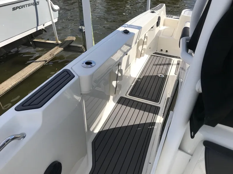 Slide: The Image of 2022 Bayliner Trophy T24CC boat interior with non-slip flooring and rod holders. - 25