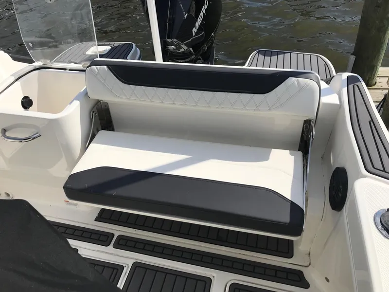 Slide: The Image of 2022 Bayliner Trophy T24CC boat seating area with black and white cushioned bench. - 27