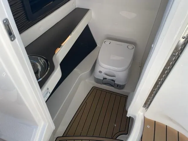 Slide: The Image of 2022 Sea Ray SLX 280 boat interior with compact toilet and sink. - 12