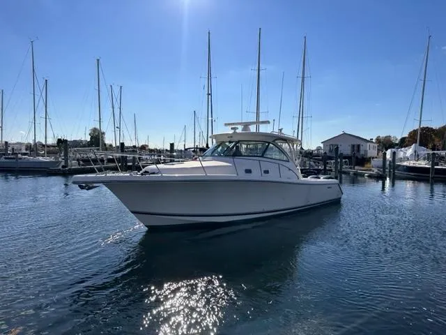 Slide: The Image of 2012 Pursuit OS 375 Offshore boat docked in a marina on a sunny day. - 1