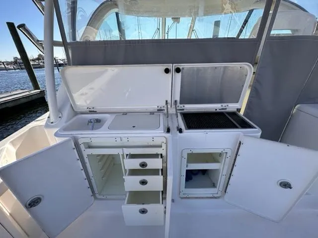 Slide: The Image of 2012 Pursuit OS 375 Offshore boat galley with storage compartments and sink. - 10