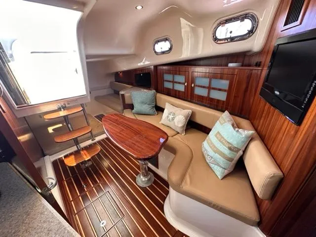 Slide: The Image of 2012 Pursuit OS 375 Offshore cabin interior with wood finishes and comfortable seating. - 17