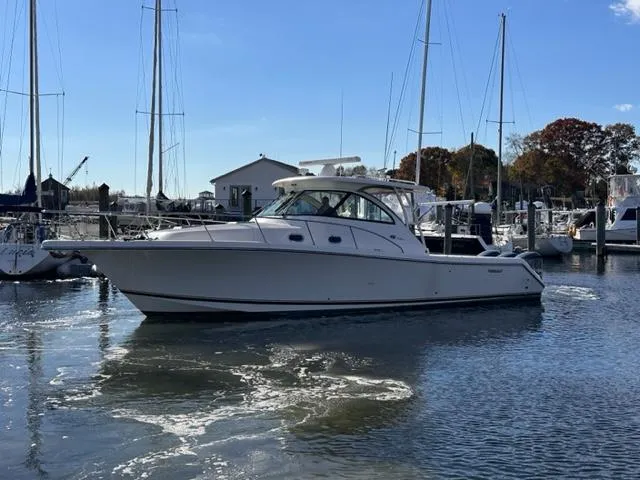 Slide: The Image of 2012 Pursuit OS 375 Offshore boat docked in a marina. - 2