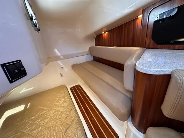 Slide: The Image of 2012 Pursuit OS 375 Offshore cabin interior with seating and wood accents - 20