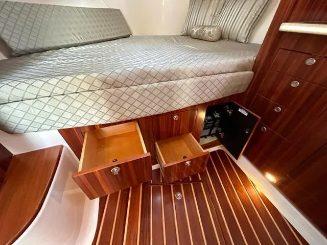 Slide: The Image of Interior cabin of 2012 Pursuit OS 375 Offshore with bed and open storage drawers. - 21