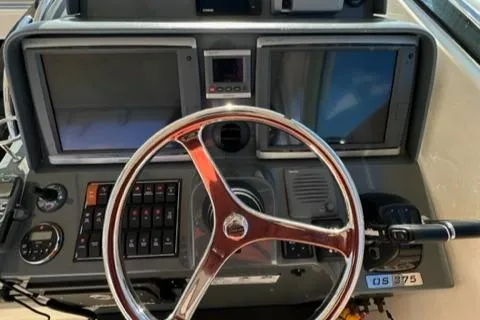 Slide: The Image of 2012 Pursuit OS 375 Offshore boat dashboard with steering wheel and navigation screens. - 31