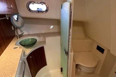 Slide: The Image of 2012 Pursuit OS 375 Offshore boat bathroom with sink, mirror, and toilet. - 32