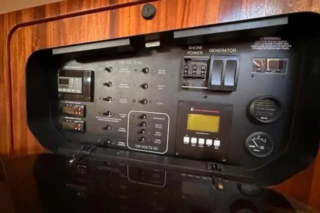 Slide: The Image of Control panel of a 2012 Pursuit OS 375 Offshore boat with shore power and generator switches. - 34