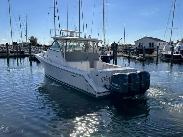 Slide: The Image of 2012 Pursuit OS 375 Offshore boat with twin Yamaha engines docked in a marina. - 5
