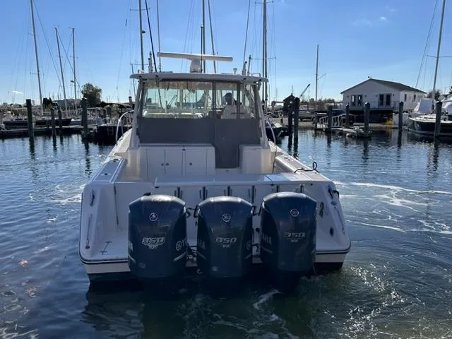 Slide: The Image of 2012 Pursuit OS 375 Offshore boat with triple Yamaha 350 engines docked in a marina. - 6