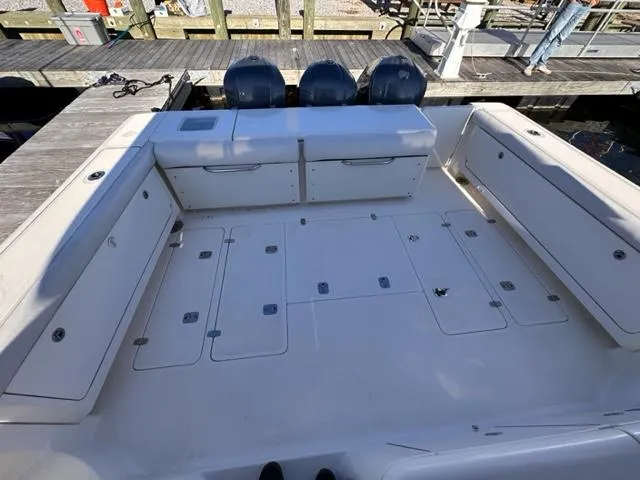 Slide: The Image of 2012 Pursuit OS 375 Offshore boat deck with storage compartments and triple outboard motors. - 7