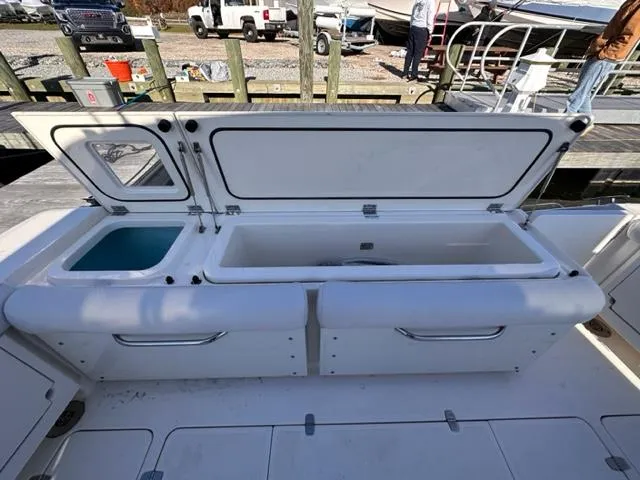 Slide: The Image of 2012 Pursuit OS 375 Offshore boat with open storage compartments at the dock. - 8