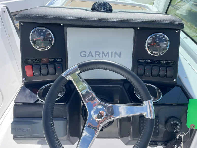 Slide: The Image of 2024 Blackfin 232DC boat dashboard with Garmin navigation system and steering wheel. - 11