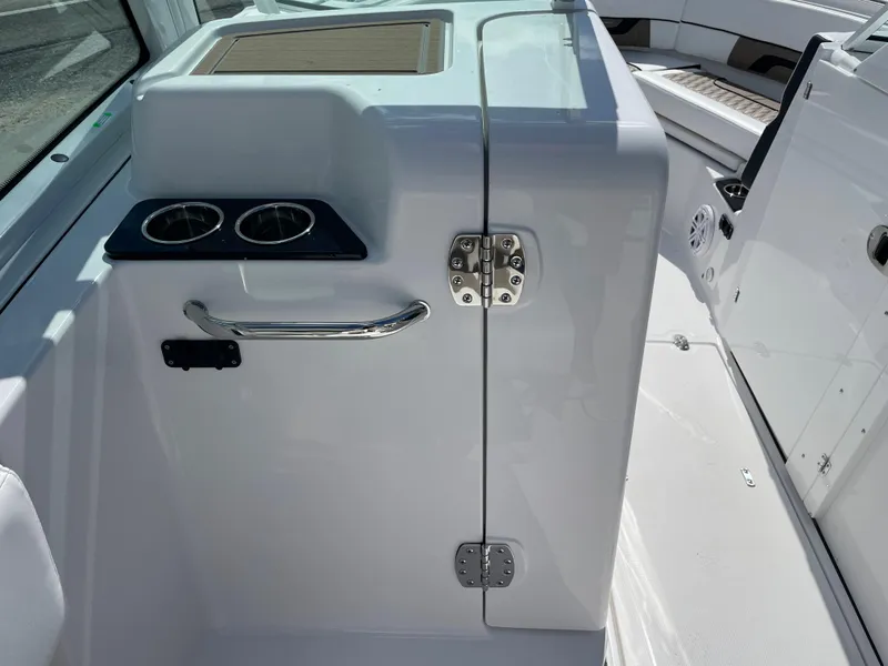 Slide: The Image of 2024 Blackfin 232DC boat interior with cup holders and storage compartment. - 12