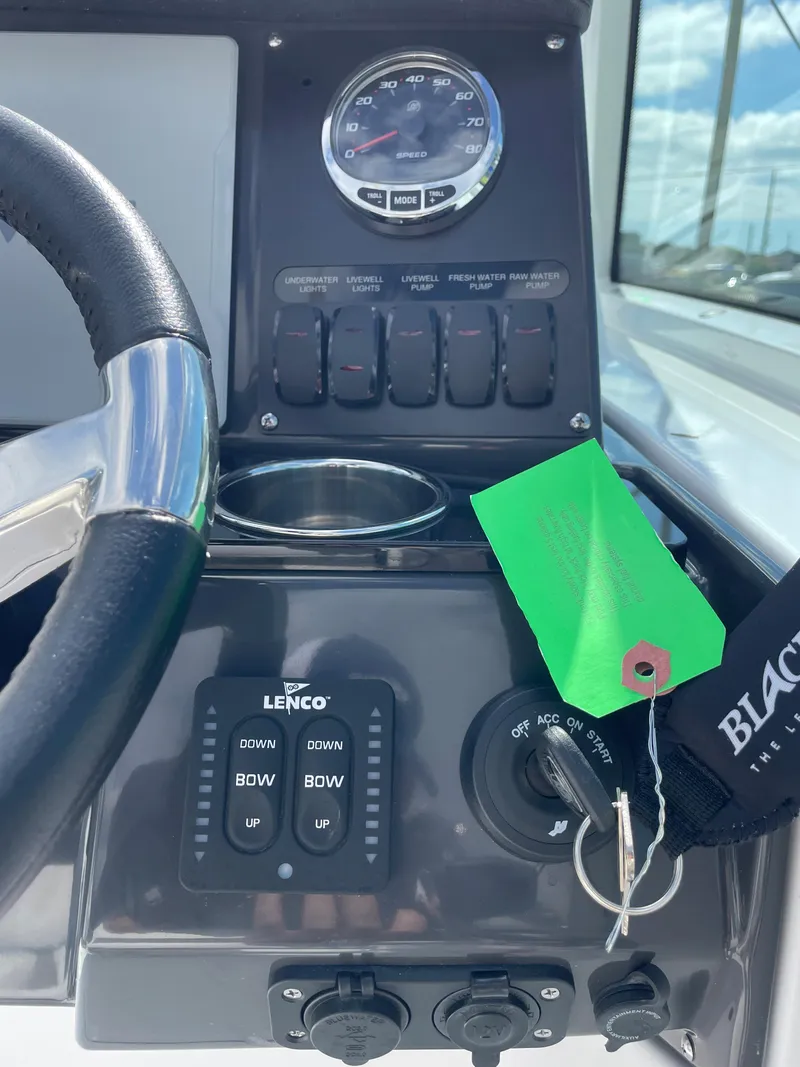Slide: The Image of Control panel of 2024 Blackfin 232DC boat with steering wheel and ignition keys. - 22