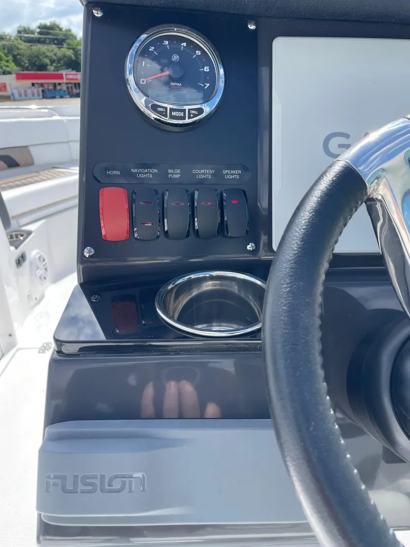 Slide: The Image of Control panel of 2024 Blackfin 232DC boat with steering wheel and cup holder. - 23
