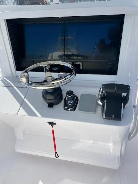 Slide: The Image of 2024 Bahama 41' Open Fisherman helm with steering wheel and controls. - 9