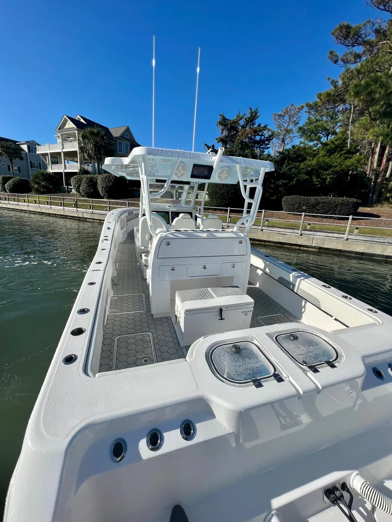 Slide: The Image of 2024 Invincible 43 Open Fisherman boat docked near waterfront homes. - 6