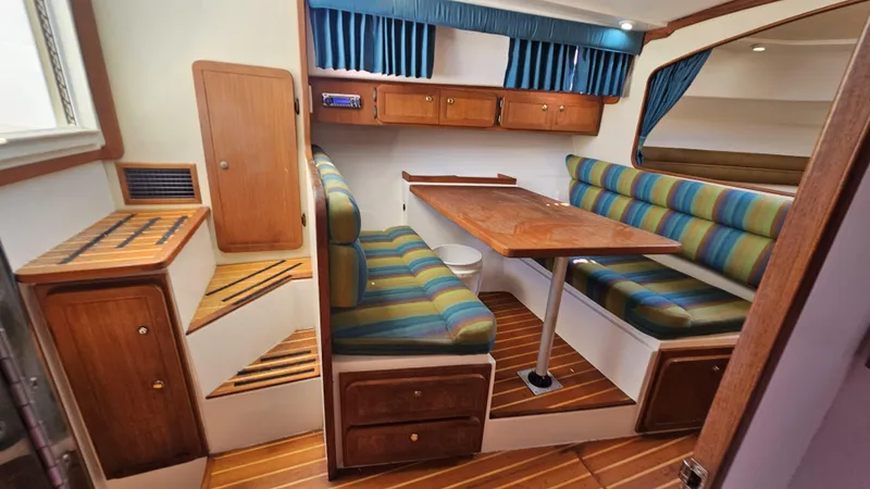 Slide: The Image of 2015 Stamas 390 Aegean interior with striped seating, wooden table, and storage cabinets. - 20