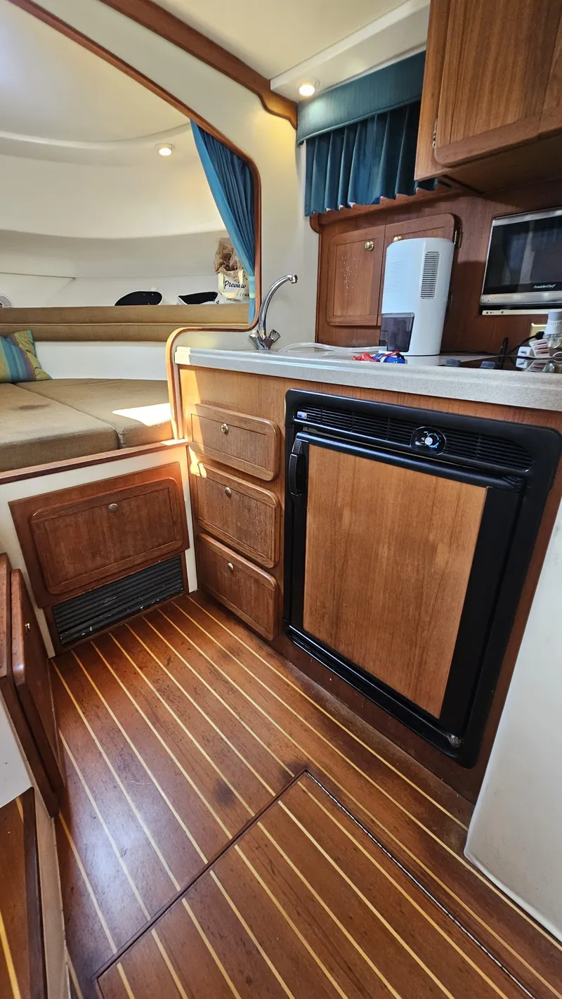 Slide: The Image of Interior of 2015 Stamas 390 Aegean boat with wood cabinetry and compact kitchen area. - 32