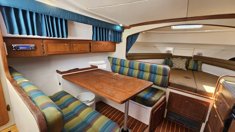 Slide: The Image of 2015 Stamas 390 Aegean cabin interior with striped seating, wooden table, and cozy sleeping area. - 33