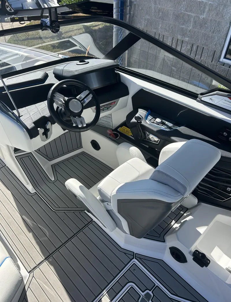 Slide: The Image of 2023 Nautique G25 boat interior with modern helm and seating. - 10