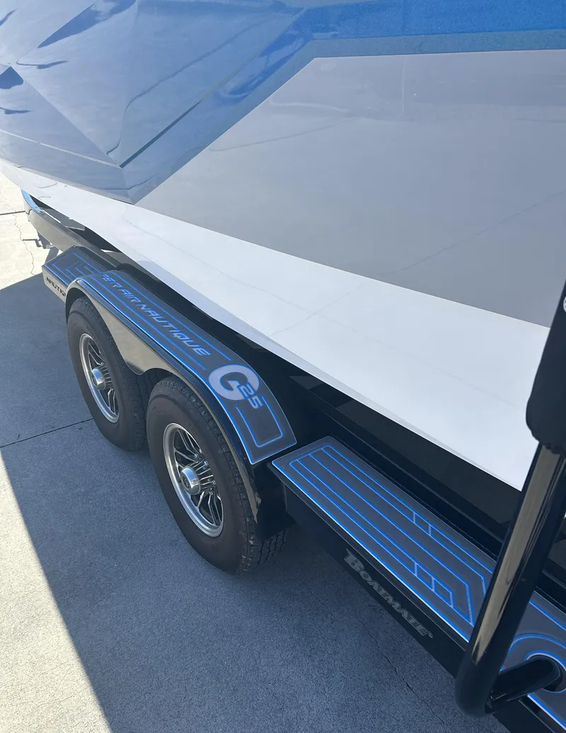 Slide: The Image of 2023 Nautique G25 boat on a trailer, close-up view of the hull and wheels. - 4