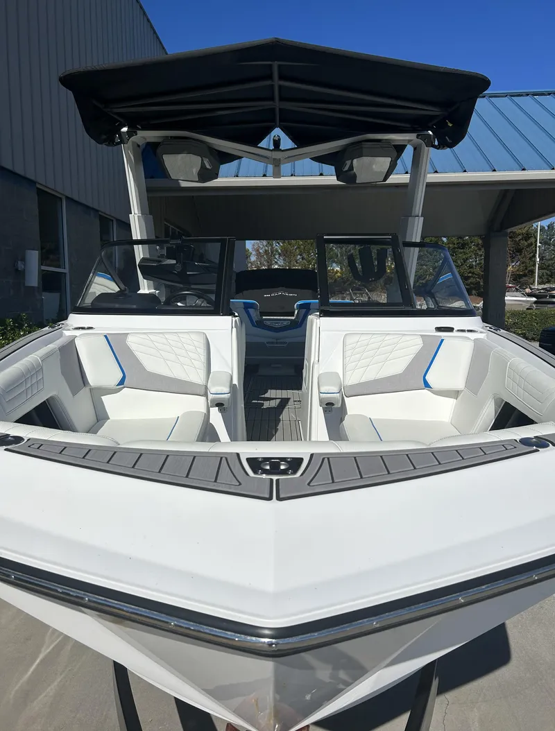 Slide: The Image of 2023 Nautique G25 boat with white interior and black canopy. - 5