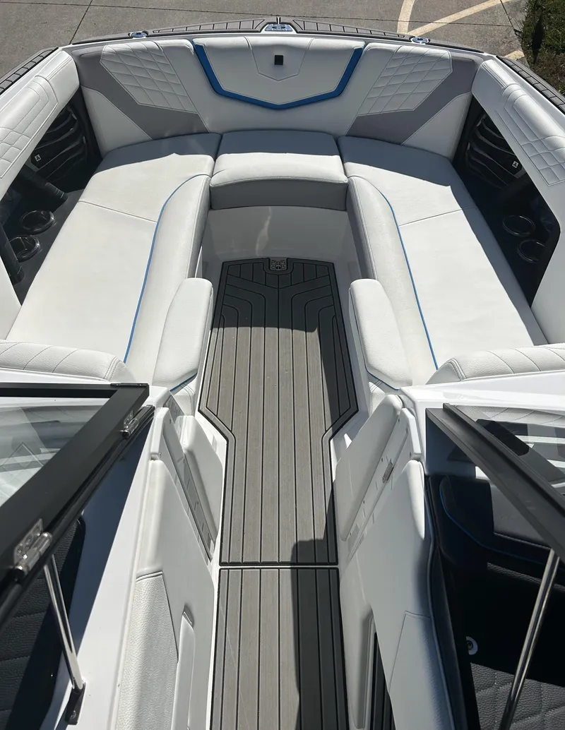 Slide: The Image of 2023 Nautique G25 boat interior with white seating and gray flooring. - 8