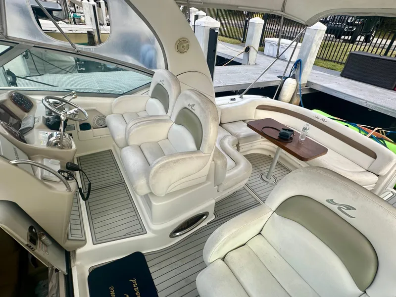 Slide: The Image of 2006 Sea Ray 340 Sundancer interior with plush seating and helm, docked at marina. - 22