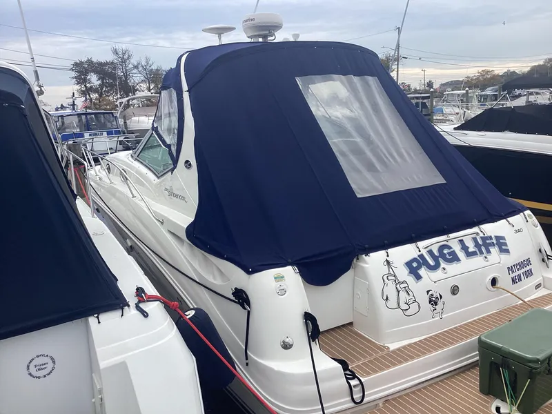 Slide: The Image of 2005 Sea Ray 320 Sundancer boat with blue canopy, docked at marina. - 1