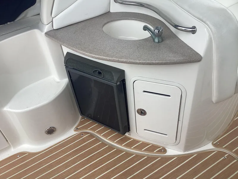 Slide: The Image of 2005 Sea Ray 320 Sundancer boat interior with sink, mini fridge, and storage. - 10