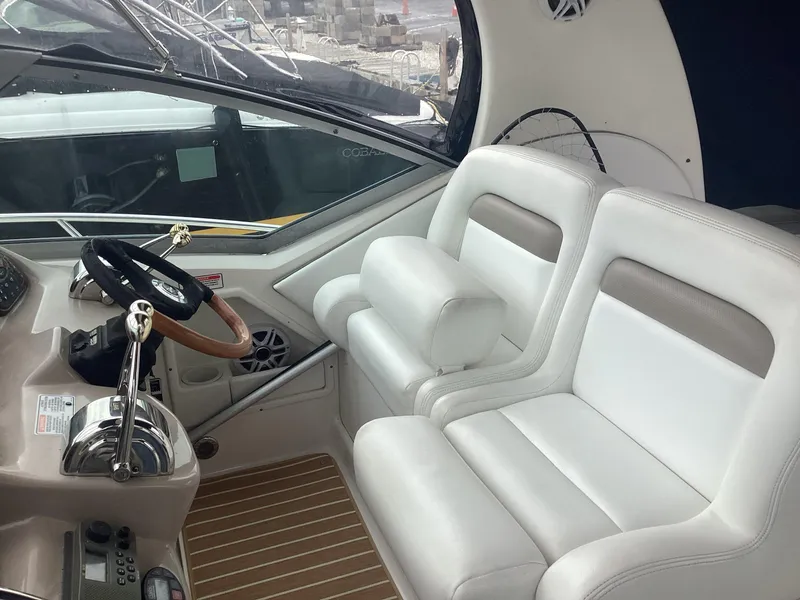 Slide: The Image of 2005 Sea Ray 320 Sundancer cockpit with white leather seats and steering wheel. - 11