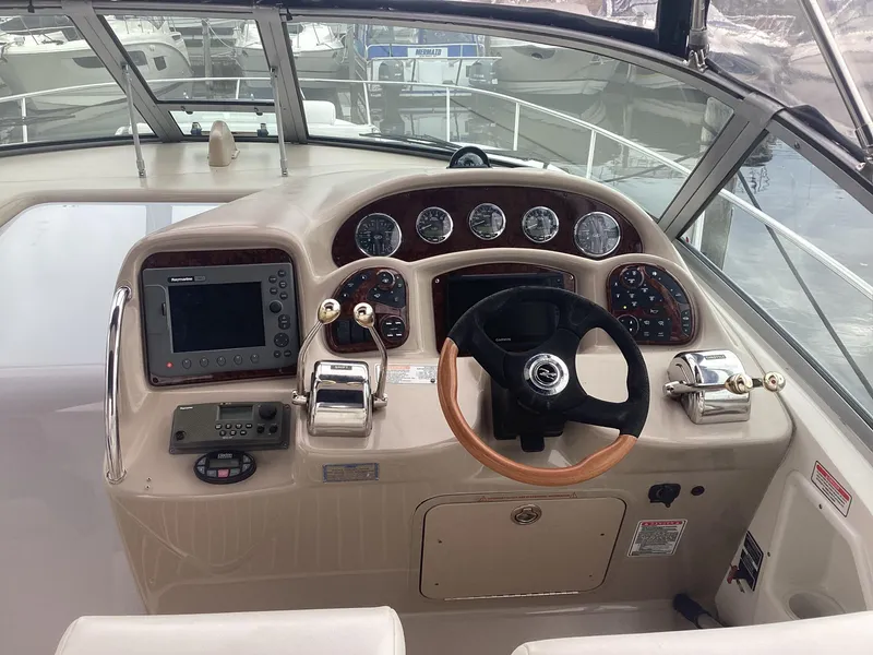 Slide: The Image of 2005 Sea Ray 320 Sundancer helm with steering wheel and navigation controls. - 12