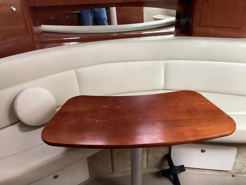 Slide: The Image of Interior of 2005 Sea Ray 320 Sundancer with wooden table and cream seating. - 17
