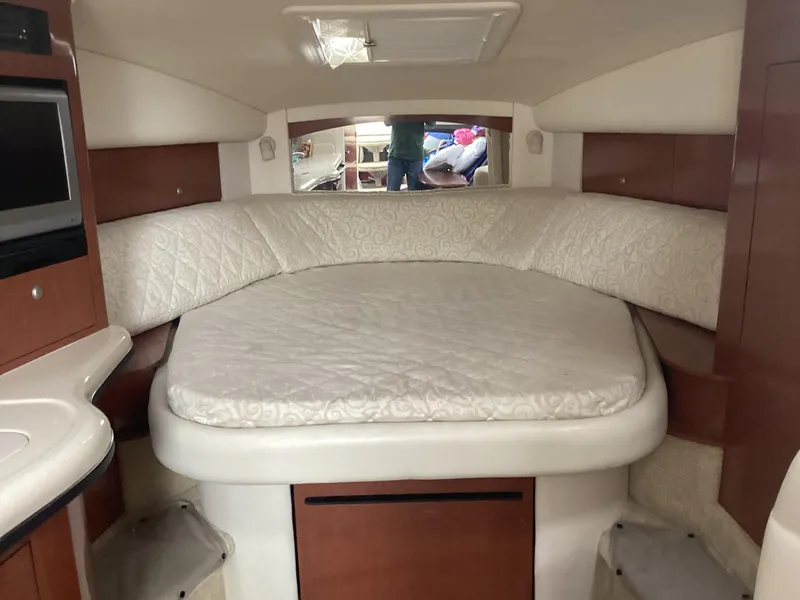 Slide: The Image of Interior cabin of 2005 Sea Ray 320 Sundancer with cozy bed and wood accents. - 18
