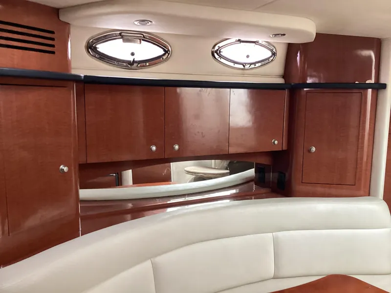 Slide: The Image of Luxurious 2005 Sea Ray 320 Sundancer cabin interior with wood cabinets and porthole windows. - 21