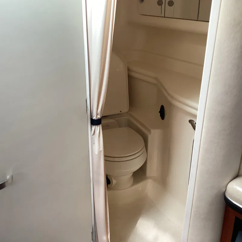 Slide: The Image of 2005 Sea Ray 320 Sundancer bathroom with toilet and curtain. - 23
