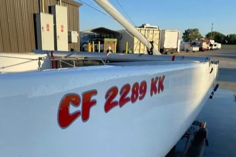 Slide: The Image of 1989 Nacra 5.8 catamaran with registration CF 2289 KK, docked outdoors. - 11