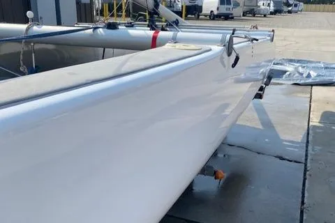 Slide: The Image of 1989 Nacra 5.8 catamaran on trailer, parked outdoors, side view. - 13