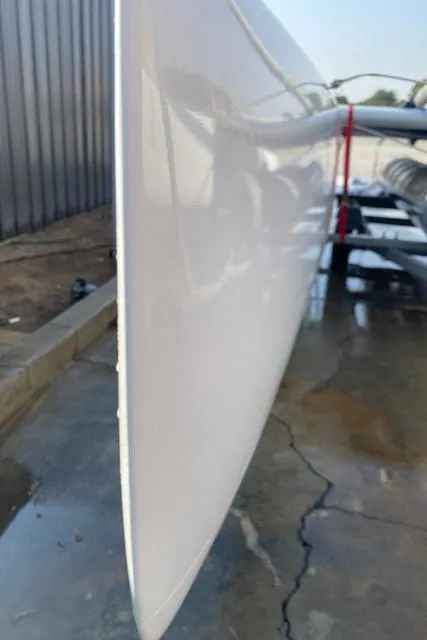 Slide: The Image of 1989 Nacra 5.8 catamaran hull, close-up view, on a wet concrete surface. - 17