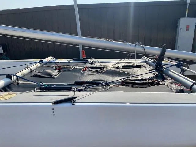 Slide: The Image of 1989 Nacra 5.8 sailboat deck with rigging and mast, outdoor setting. - 5