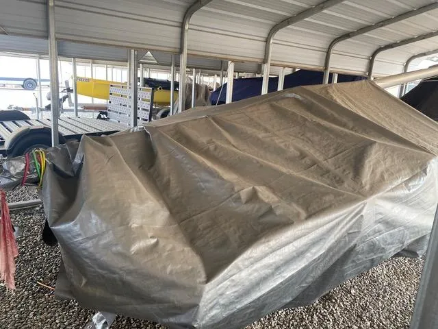 Slide: The Image of Covered 1989 Nacra 5.8 sailboat stored in a sheltered area. - 7