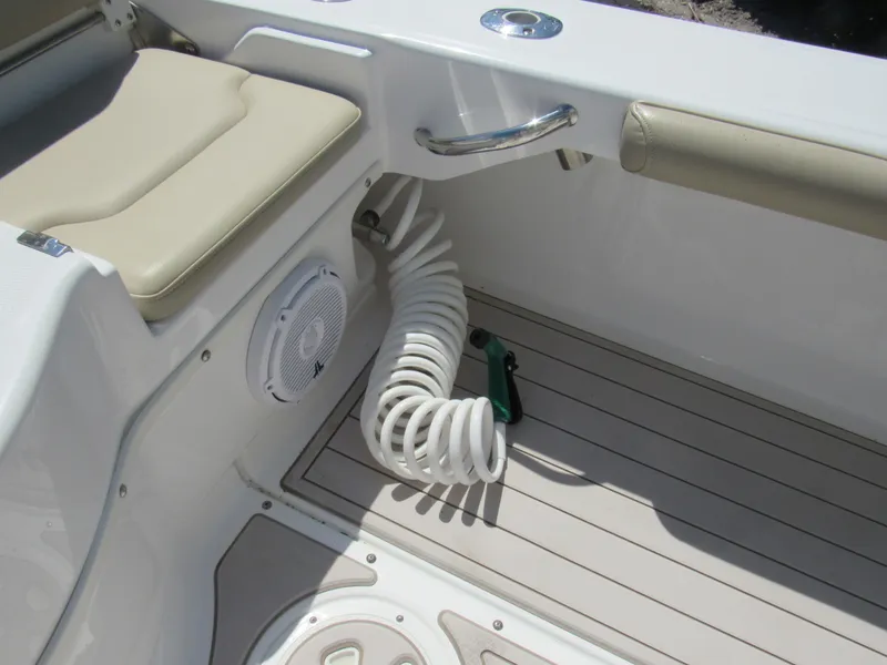 Slide: The Image of 2019 Everglades 243 CC boat interior with coiled hose and cushioned seating. - 12