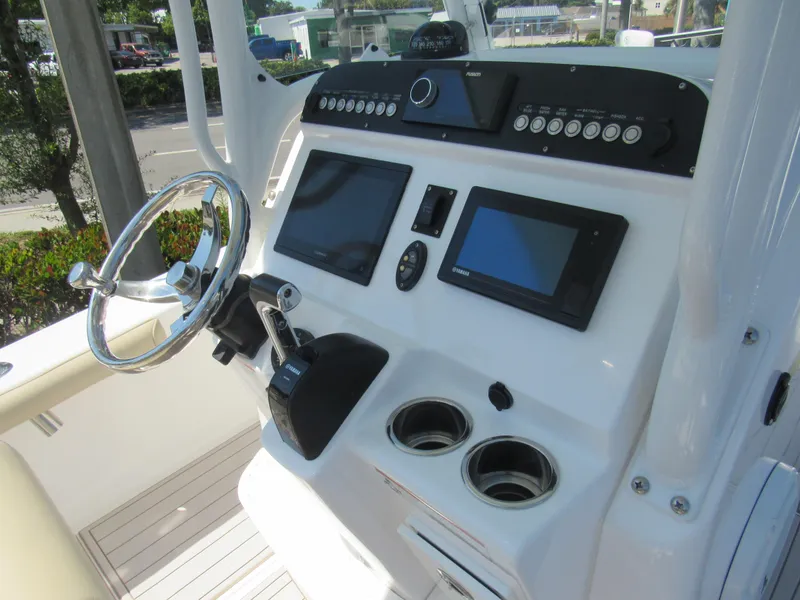 Slide: The Image of 2019 Everglades 243 CC boat console with steering wheel, dual screens, and control panel. - 5