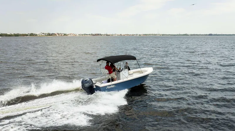 Slide: The Image of 2024 Parker 1801CC boat cruising on open water under a clear sky. - 1